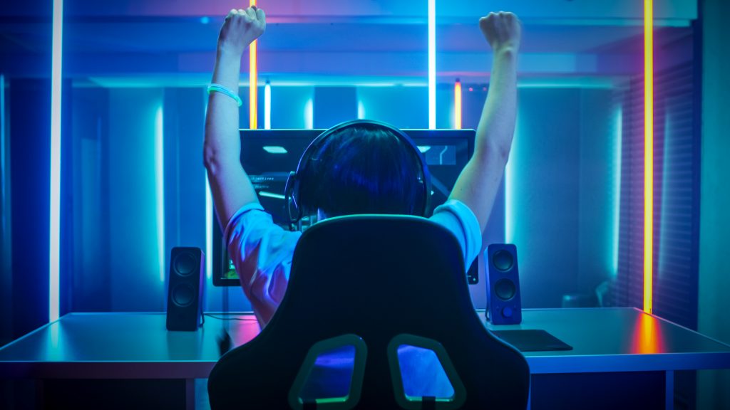 Gamer örül a győzelmének a neon világítású szobájában