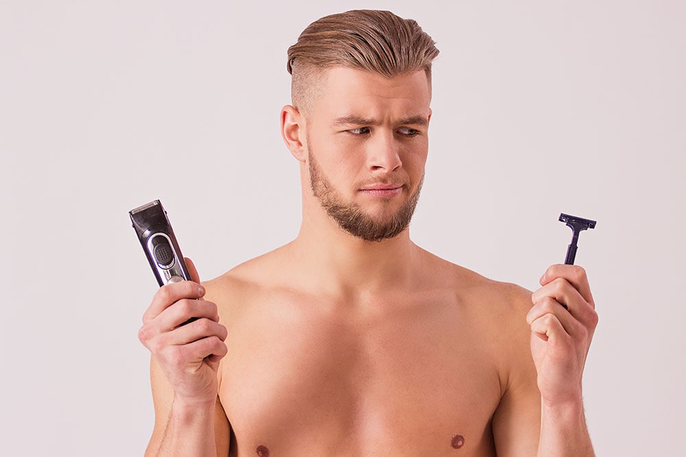 fiatal férfi, jobb kezében elektromos borotva, bal kezében sima borotva