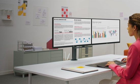 Fiatal hölgy dolgozik két monitoron