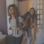 Fiatal lányok hátizsákkal a hátukon, kollégiumba költöznek