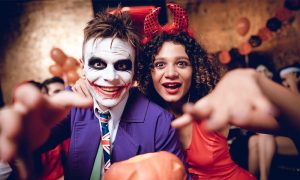 halloween partyn ördögnek öltözött nő, Joker férfi